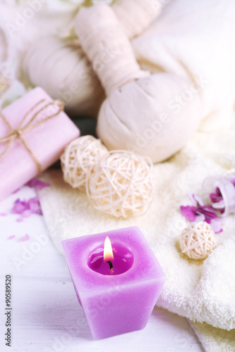 Massage bags with spa treatment and flowers on wooden table background