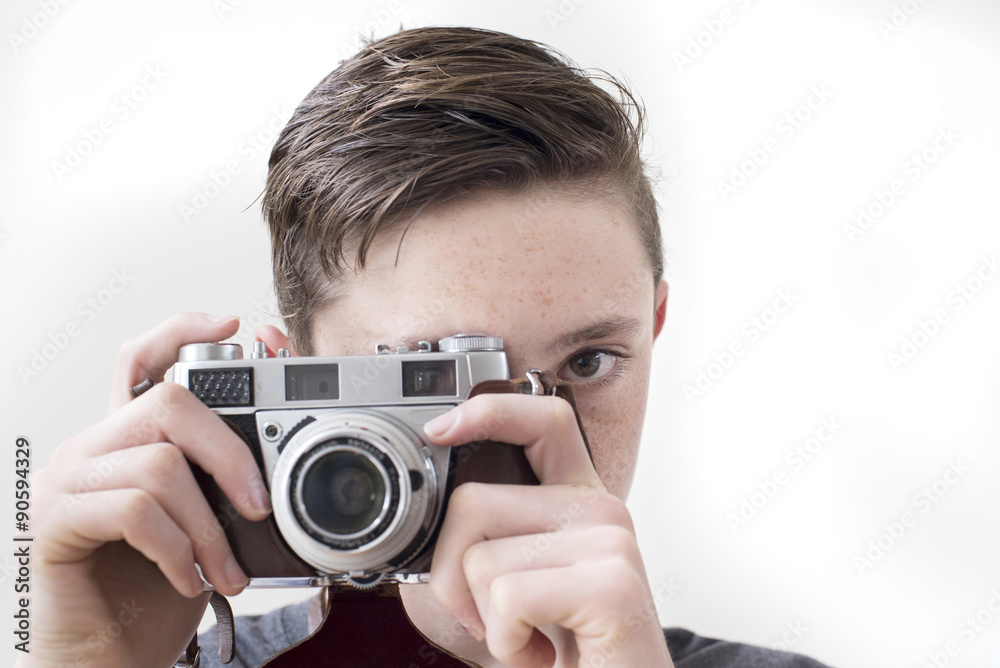 Boy holds retro style 35mm camera ready to take a picture Boy holds retro style 35mm camera ready to take a picture