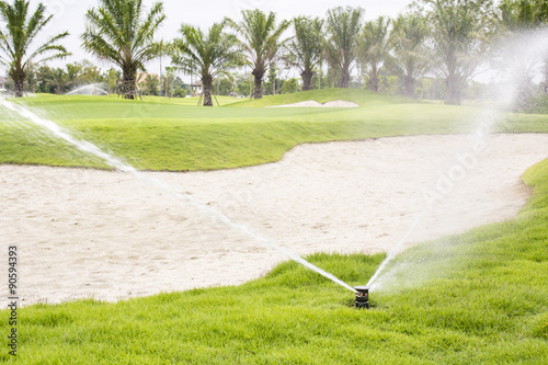Sprinkler watering golf course.