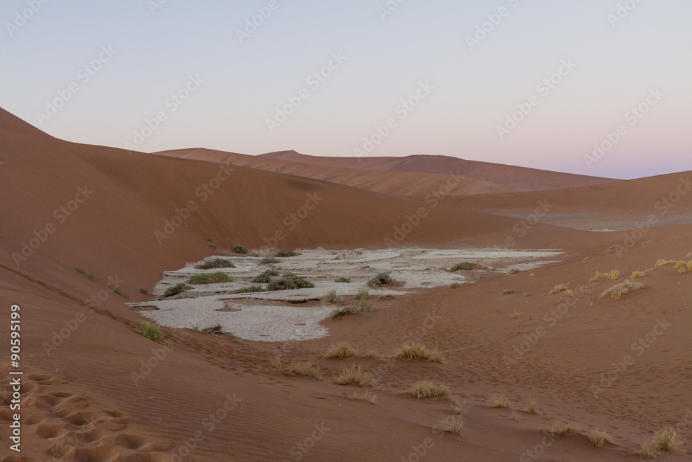 Sunrise over the dunes at Sossousvlei, looking down at a clay pan. Sunrise over the dunes at Sossousvlei, looking down at a clay pan.