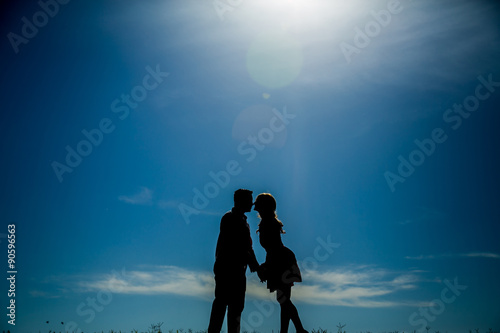 Silhouette of an in love couple leaning over to kiss