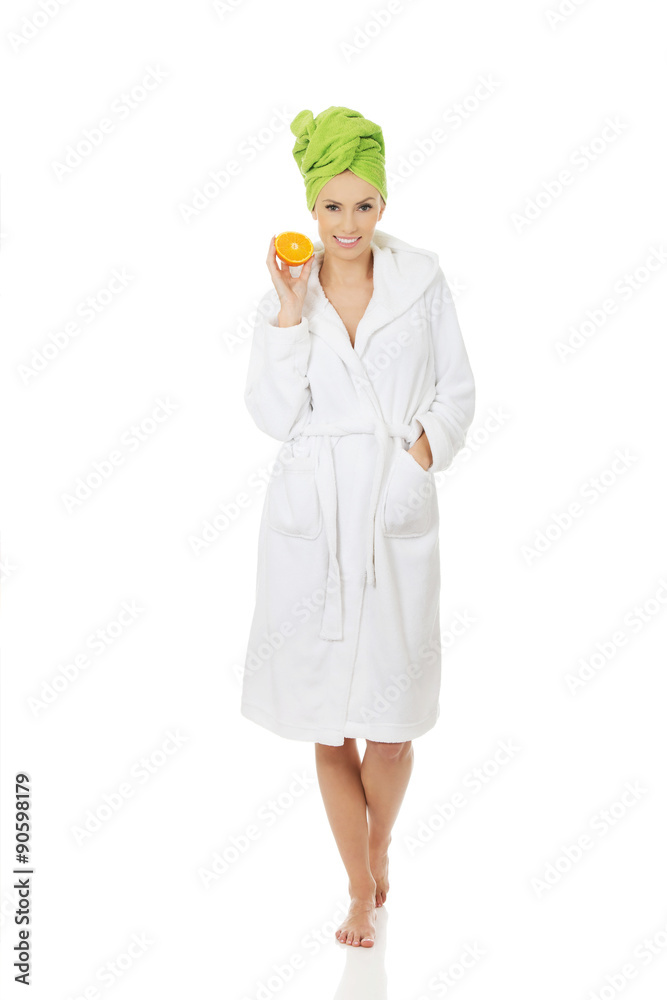Spa woman in bathrobe holding orange. Spa woman in bathrobe holding orange.