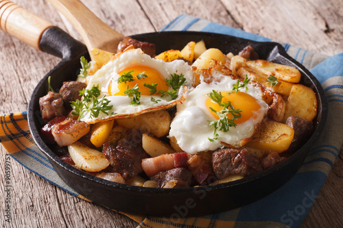 Tyrolean fried potatoes with meat, bacon and eggs in a pan. horizontal
 photo