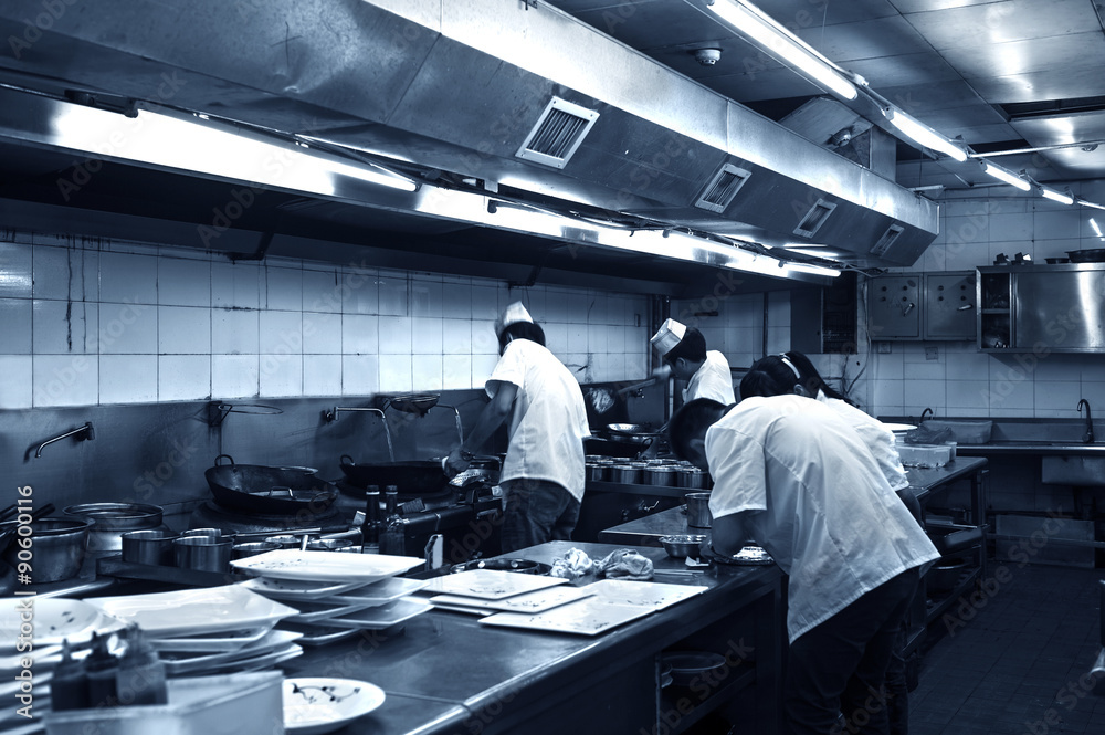 Obraz premium Crowded kitchen, a narrow aisle, working chef.