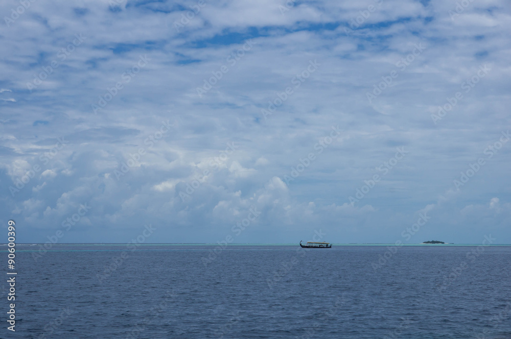 Seascape with boat and cloudy sky