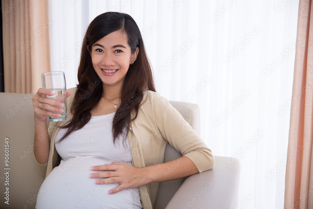 Pregnant asian woman drinking a glass of water Pregnant asian woman drinking a glass of water