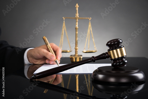 Judge Writing On Paper At Desk
