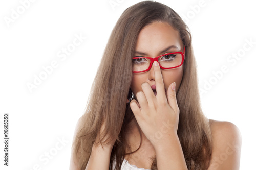 pretty girl adjusts her glasses with a finger