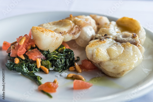 Grilled monkfish garnished spinach with cedar nut and tomatoes