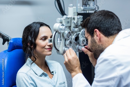 Optician using a phoropter on his patient photo