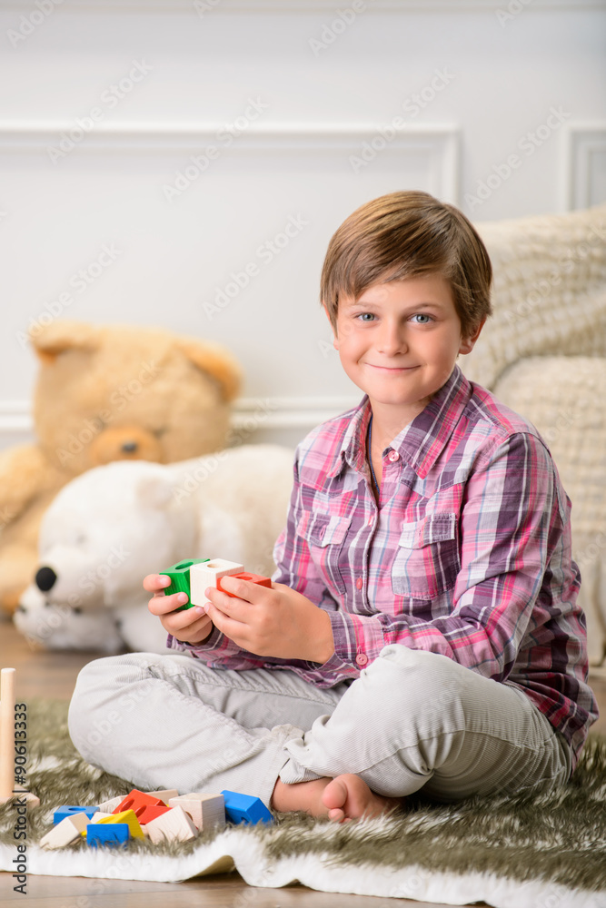 Cheerful boy playing on the carpet Cheerful boy playing on the carpet