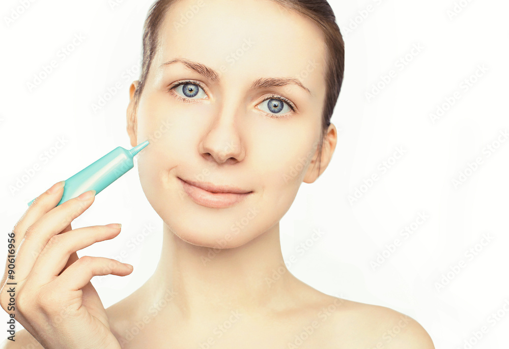 Portrait of beautiful woman applying cream on a white background Portrait of beautiful woman applying cream on a white background