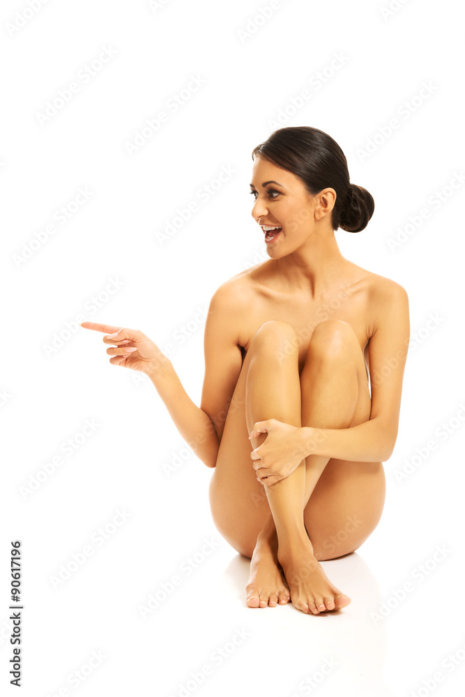 Serene woman sitting, pointing to the left Serene woman sitting, pointing to the left