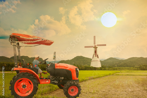 asian little boy driver tractor on rice field in the sunset back