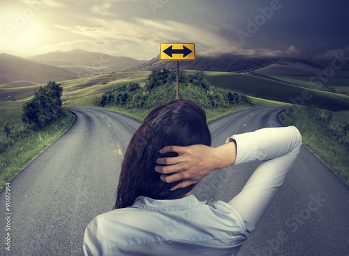 business woman in front of two roads thinking deciding photo