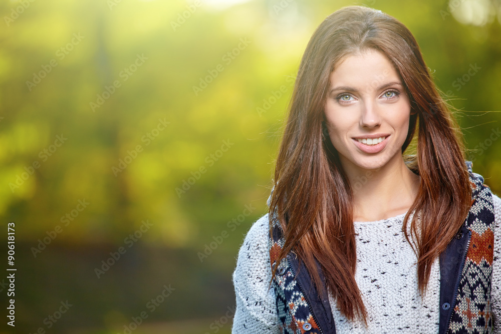 Beautiful woman standing in a park in autumn