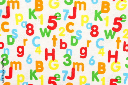 Numbers and letters on white fabric. Colorful pattern with numbers and letters as background.