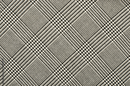 Black and white houndstooth pattern in squares. Black and white wool twill pattern. Woven dogstooth check design as background.