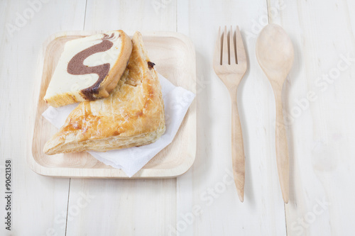 Pie and wooden fork and spoon on wooden background