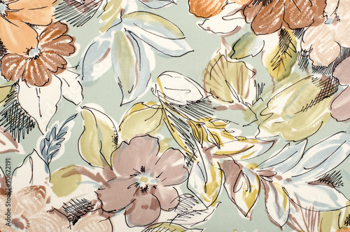 Floral pattern on fabric. Brown flowers with blue and green leaves print as background.