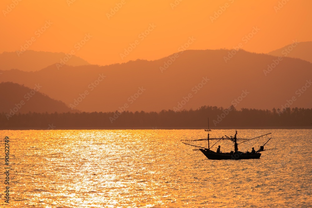 Sunset with wooden fishing boat in Thailand