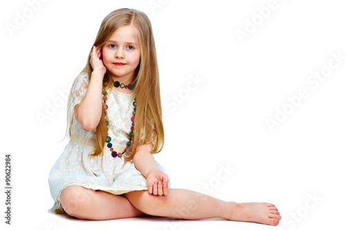 girl child with long blond hair siting on a floor.fashion portr