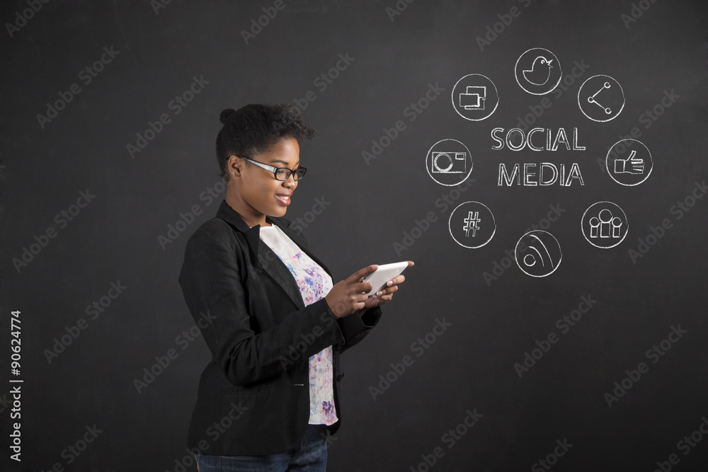 African American woman with tablet social networking on blackboard background African American woman with tablet social networking on blackboard background