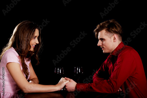 Couple with wine by a table.