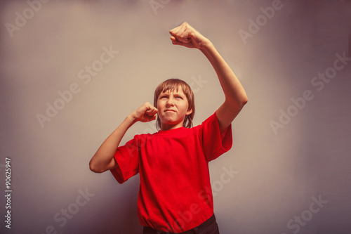 Boy, teenager, twelve years in a red shirt,  showing his fists r © maxximmm