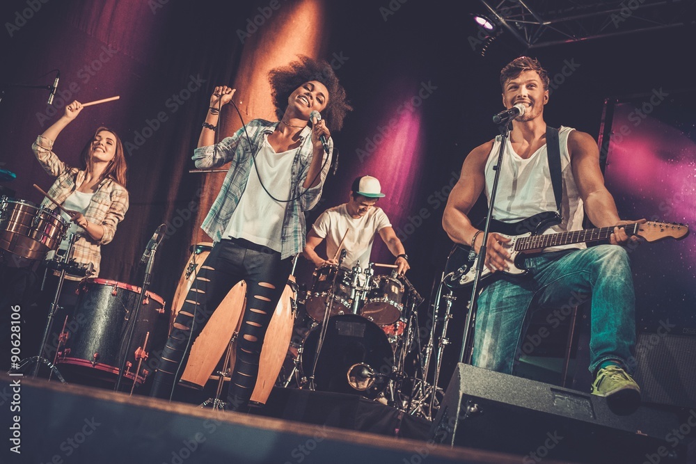 Fototapeta premium Multiracial music band performing on a stage