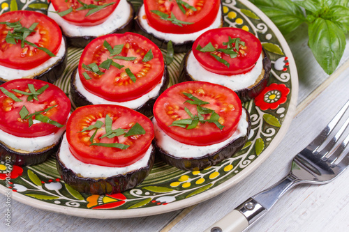 Grilled eggplant with spicy sour cream sauce, tomatoes and basil