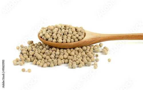 White pepper in wooden spoon on a white background