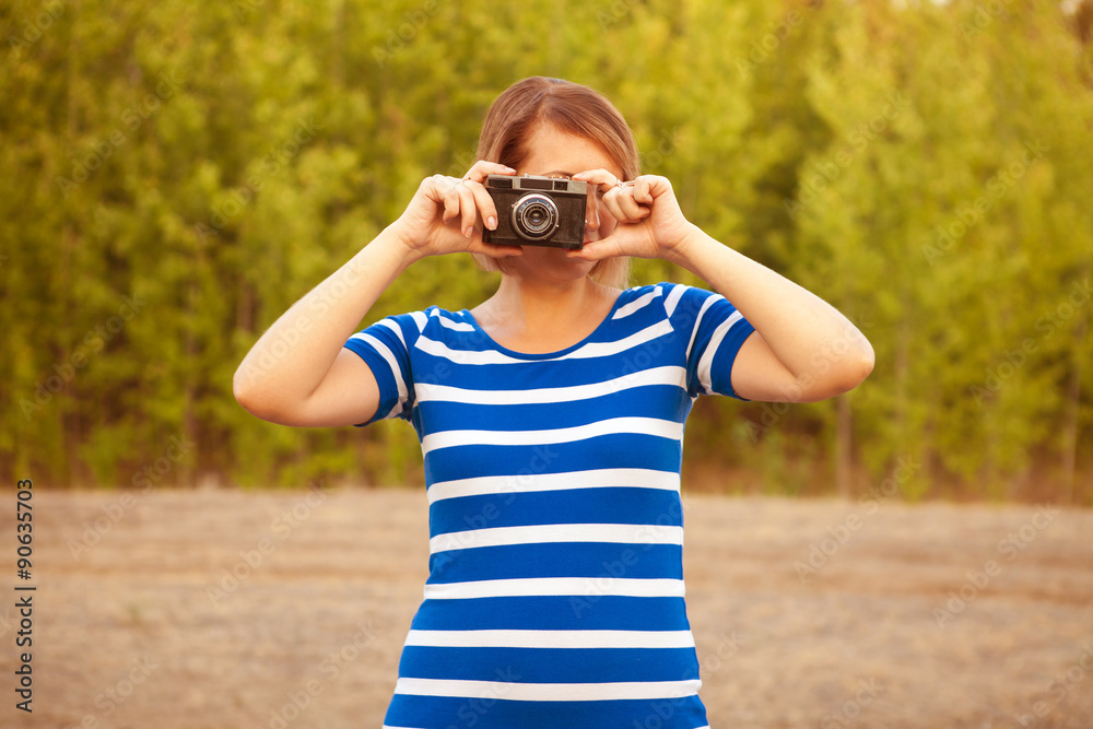 young woman in a striped dress photographed on an old film camer young woman in a striped dress photographed on an old film camer