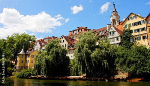 Häuserfassaden entland des Neckars in Tübingen mit Bäumen und Stocherkähnen