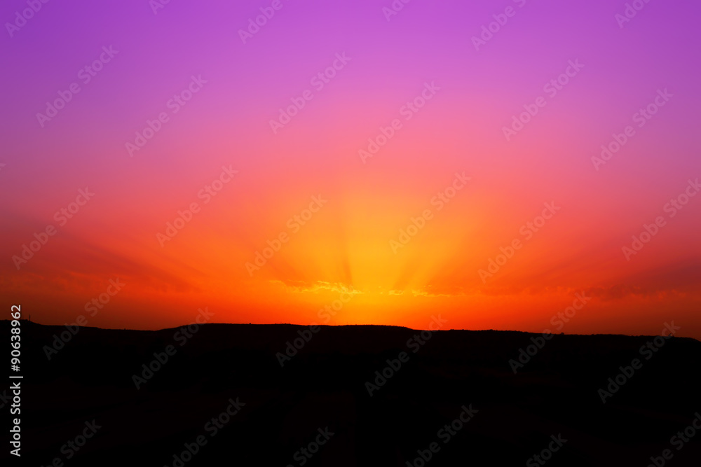 Raggi di sole in una foto di un tramonto rosso e viola
