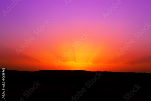 Raggi di sole in una foto di un tramonto rosso e viola