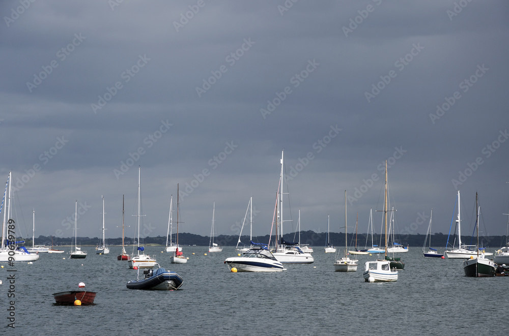 Yachts anchored in the bay before the storm in sunset light. Northern Ireland.