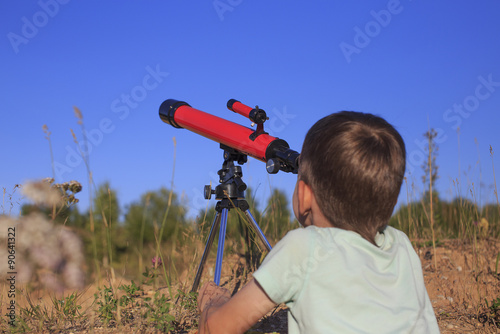 young astronomer.a young astronomer studies the celestial bodies through a telescope while lying in the park