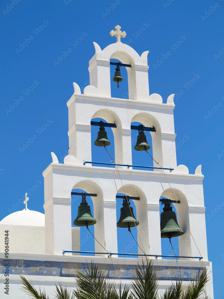 White church bell tower against blue sky in Greece