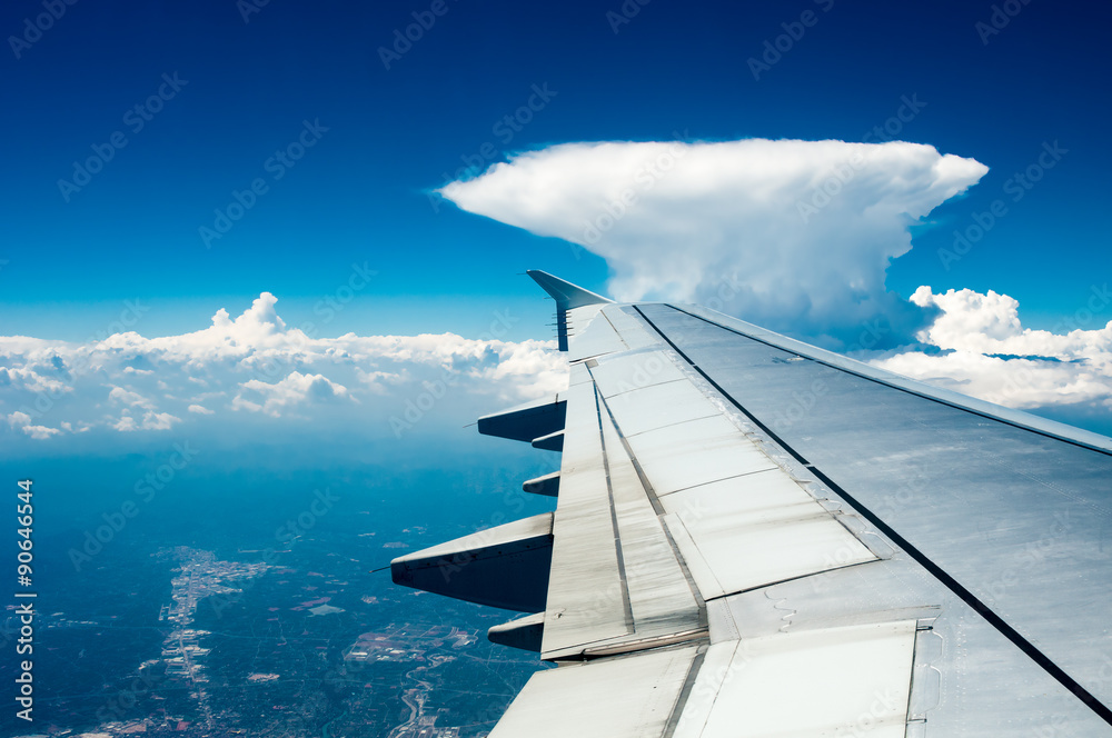 Wing of airplane flying above the cloud like nuclear mushroom Wing of airplane flying above the cloud like nuclear mushroom
