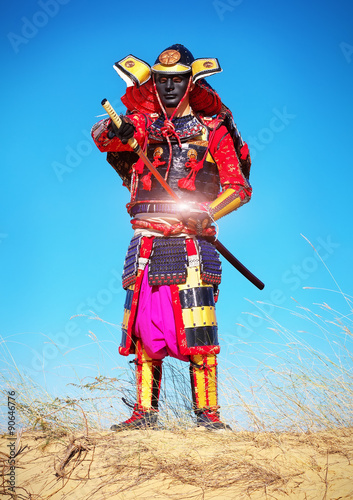 Man in samurai costume pulls out his powerfull hot sword. 