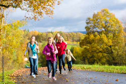 Mädchen rennen bei Familien Spaziergang im Herbst Park vorweg