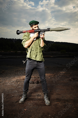 Schilderij op canvas Man with RPG bazooka posing on dark field