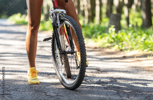 Rear view of mountain bike and woman's legs.