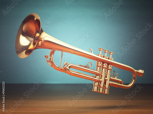 Polished brass trumpet on green background. photo