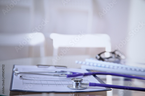 Purple stethoscope on the glass desk