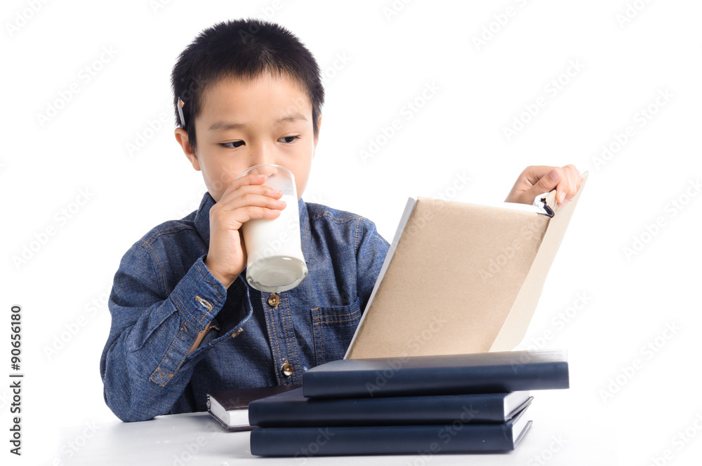 Young boy has a cup of milk reading book Young boy has a cup of milk reading book