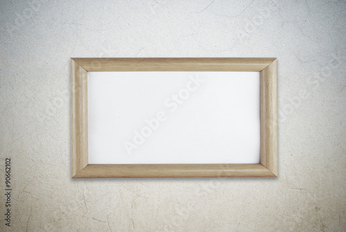 Blank wooden picture frame on grunge cement wall background