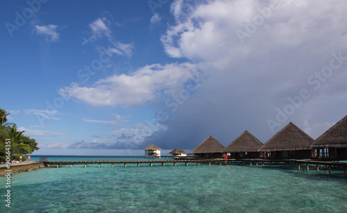 Maldivian resort on a clear day under a cloudy sky