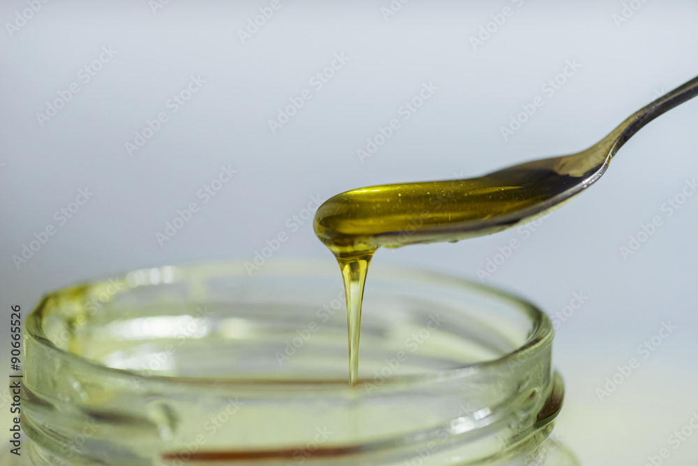 Honey Flowing from Spoon into Bottle Honey Flowing from Spoon into Bottle